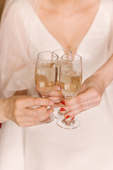 a glass of champagne in the hands of the bride and her bridesmaids