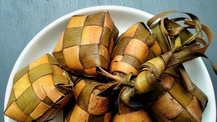 Ketupat, special dish served at Eid Mubarak or Ied Fitr celebration in Indonesia. Ketupat is  is a type of dumpling made from rice packed inside a diamond-shaped container of woven palm leaf pouch.