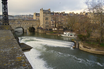 picturesque Pulteney Bridge, Pulteney Weir and river Avon in Bath England on a cloudy day