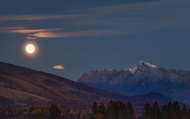 Full moon over mount Krivan peak - Slovak symbol - forest trees silhouettes in foreground, evening...