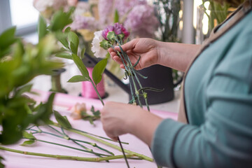 close up skilled female flower shop business owner crafts a breathtaking arrangement of pink and yellow roses flowers, bringing joy and happiness to her customers.