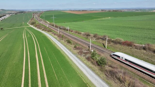 Dauborn, Germany - April 05, 2023: A German ICE highspeed train passing by on the Frankfurt-Cologne line near Dauborn, Germany. The maximum speed of these trains is around 320kmh.