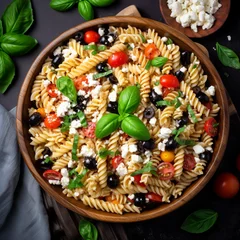 Foto auf Acrylglas A food photograph of a delicately arranged plate of rustig fussili pasta with green basil, red cherry tomatos, feta chesse and black olives - Generative AI © Luca