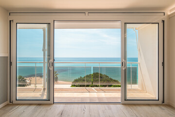 Picturesque view from a guest house through panoramic window with terrace to the sea on a sunny...