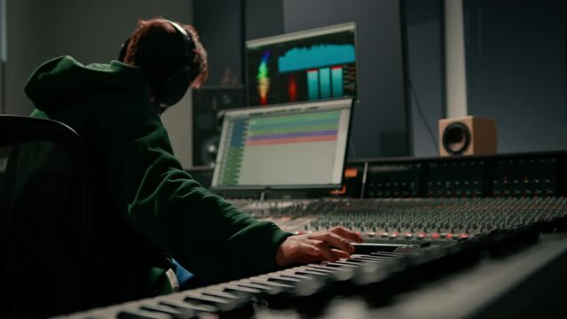 Male hands play electronic piano keyboard Fingers tap keys midi controller Musician produces song in recording studio