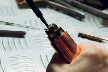 Specialist replaces spring for smoking vape.Professional maintaining electronic cigarette in...