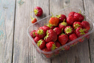 Juicy ripe red strawberry in a plastic container