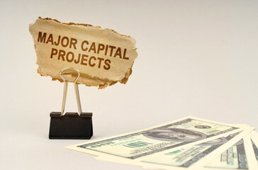There is money on the table, next to it is a cardboard sign with the inscription - Major Capital...