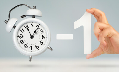 Change time, minus one hour. Fall back, on a gray background. A white alarm clock indicates that...
