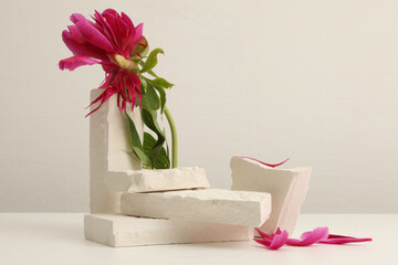 Flower and stones platform podium on beige background. Minimal empty display product presentation scene.