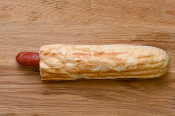 french hot dog on wooden board on black background, fast food.