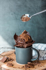 Delicious freshly baked chocolate muffins on a dark background. Delicious cupcake close-up. The context of a bakery with pastries. Confectionery products.