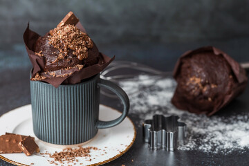 Delicious freshly baked chocolate muffins on a dark background. Delicious cupcake close-up. The...
