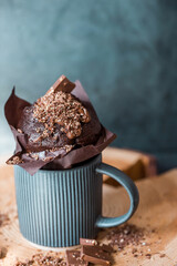 Delicious freshly baked chocolate muffins on a dark background. Delicious cupcake close-up. The context of a bakery with pastries. Confectionery products.