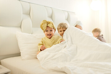 Children lie in bed in bathrobes after taking a bath.