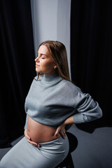 Cute pregnant woman in sweater and skirt with tummy. Happy elegant pregnant woman. A woman is expecting a child