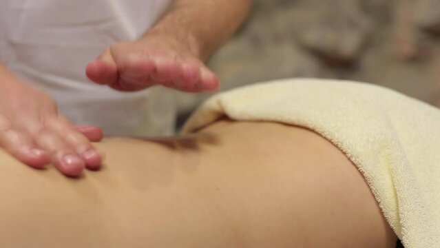 The hands of a masseur doing a massage. Close-up of masseur's hands.