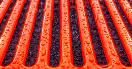 Red lacquered lattice part of a retro car. Fonby bright orange covered in raindrops. Orange with black stripe.