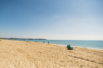 Fototapeta na wymiar personas en la playa paseando y relajados 