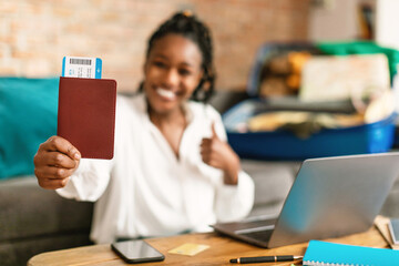 Travelling, vacation, tourism concept. Happy black woman showing passport with flight tickets, preparing for trip