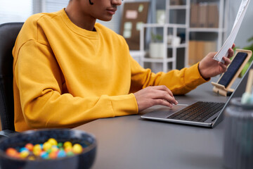 Side view closeup of young black man working or studying at home office workplace, copy space