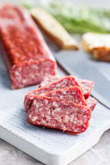 Smoked .sausage. Sliced salami on cutting board.