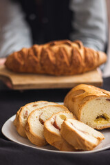 pan de jamon y queso en tajas y de fondo una hermosa mujer sosteniendo un pan de cajada crocante