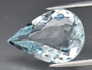 Natural blue aquamarine gem on gray background