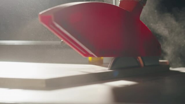 Close-up of carpenter cutting a wooden plank, circular saw on wooden factory, furniture production, handmade craft table.