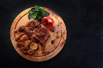Grilled chicken with new potatoes on a wooden board. Grilled chicken Tabaka . Georgian cuisine. Copy space.Flat lay.Top view.