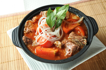 Tomato and Beef Brisket Casserole noodles served in borth isolated on table top view of Claypot
