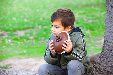happy little boy with easter chocolate egg in the park