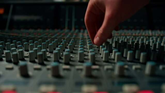 Close-up of hand on mixing console adjusting faders The sound engineer works in the studio Professional recording studio