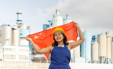 Portrait of teenage girl in blue overalls with flag of China in her hands against the backdrop of a...