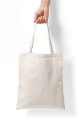 Female hand holding a blank tote canvas bag mockup isolated on a transparent background, PNG. High...