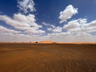 Fototapeta na wymiar Merzouga, Morocco, Africa, panoramic road in the Sahara desert with view of the beautiful sand dunes, 4x4 trip, blue sky and white clouds