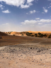 Merzouga, Morocco, Africa, panoramic road in the Sahara desert with view of the beautiful sand dunes, 4x4 trip, blue sky and white clouds