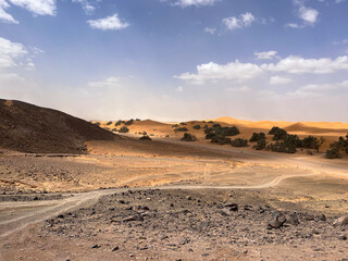 Merzouga, Morocco, Africa, panoramic road in the Sahara desert with view of the beautiful sand dunes, 4x4 trip, blue sky and white clouds