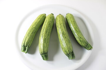  close up of 3 zuchinis on a white background