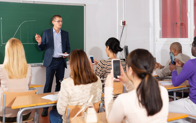 Male speaker giving lesson for adult students in classroom