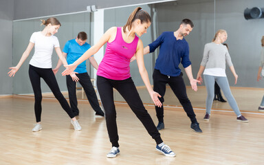 Fototapeta na wymiar Smiling women and men of different ages warming up during dance class.