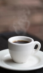 beautiful white cup with hot coffee smoke rising and blurred background