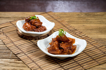 boneless smoked fish with chopsticks served in dish isolated on mat top view on wooden table Hong Kong food