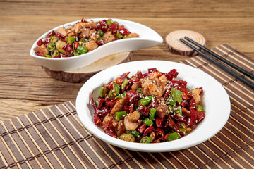 Spicy Red Chilli Fried Chicken with chopsticks served in dish isolated on mat top view on wooden table Hong Kong food