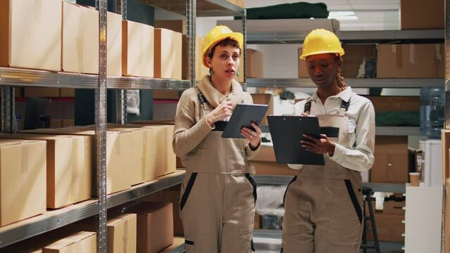 Diverse employees working on inventory and logstics to plan transportation and delivery, industrial shipment. Female workers examining products and goods on warehouse shelves.