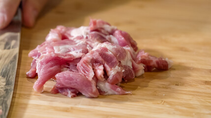 Close up of chef Butcher cutting pork meat with knife on kitchen, cooking food. The chef butcher preparing pork meat for cooking.