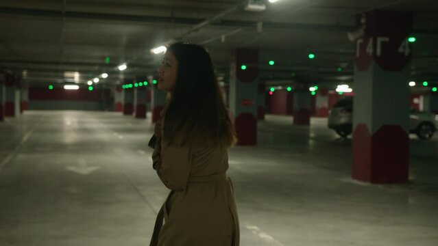 Back view frightened Asian woman scared girl running in parking dark underground subway afraid stressful lady victim feel panic run from pursuit threat dangerous chase alone female walking look behind