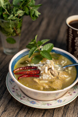 Platillo mexicano menudo blanco con hierbas y chile con taza de cafe de fondo sobre mesa rustica de madera