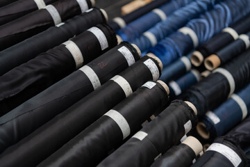 Obraz premium Collection of fashionable fabrics. Samples of different natural fabrics for sewing a fashion collection of clothes. Large selection of fabrics in the store or tailor warehouse.