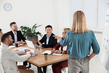 Businesswoman having meeting with her employees in office